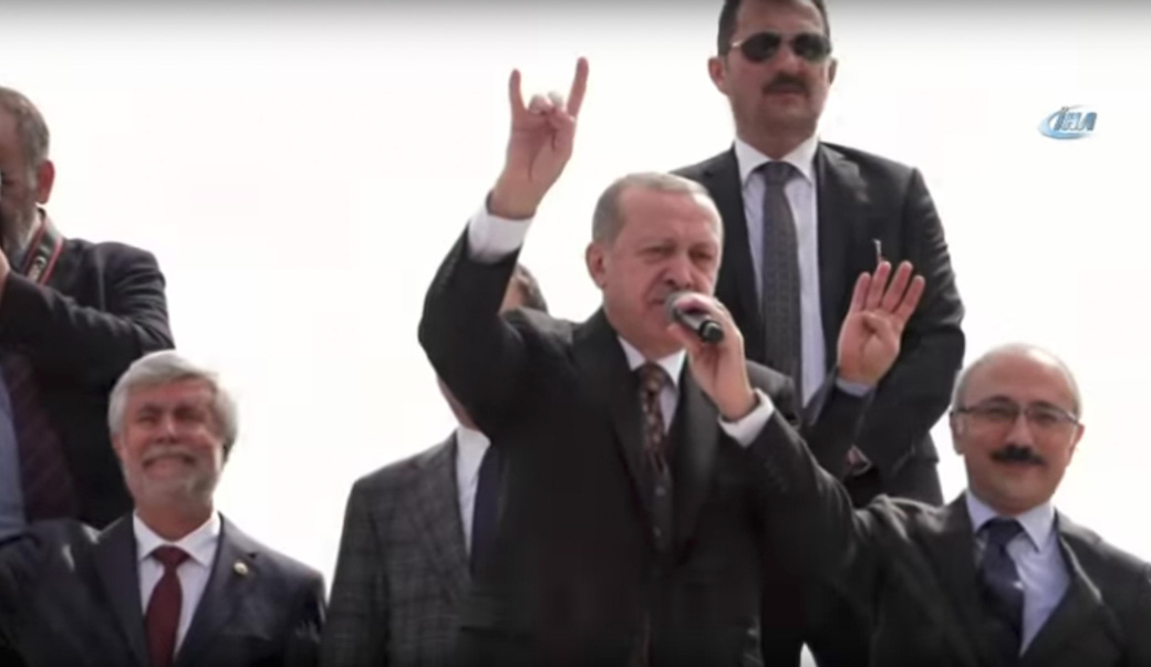 Erdoğan gör den högerextrema ungdomsorganisationen Grå vargarnas handgest.